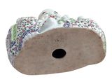 a figurine of a cat laying on top of a piece of wood
