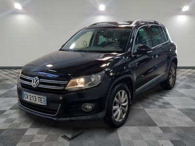 the black volkswagen tiguan is parked in a large room