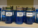 Plusieurs bocaux bleus munis d'étiquettes sont alignés sur une étagère