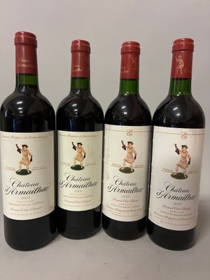quatre bouteilles de vin rouge sont alignées sur une table