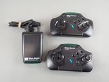 two remote controls and a charger sitting on a table