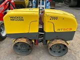 yellow and black machine sitting on top of a dirt field
