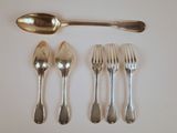 cinq fourchettes et une cuillère sur une table blanche