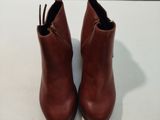 bottines en cuir marron avec des fermetures éclair sur un fond blanc