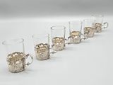 six verres à shot alignés sur une surface blanche