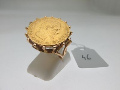 Gros plan sur une bague ornée d'une pièce d'or
