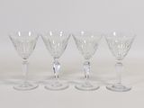 quatre verres à vin transparents posés sur une table blanche