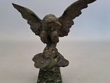 une image représentant une statue en bronze d'un aigle sur un socle