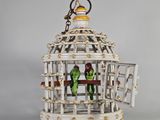 un petit oiseau dans une cage à laquelle est accroché un porte-clés