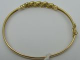 un gros plan d'un bracelet en or orné d'un nœud