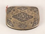 a small metal box with a floral design on it