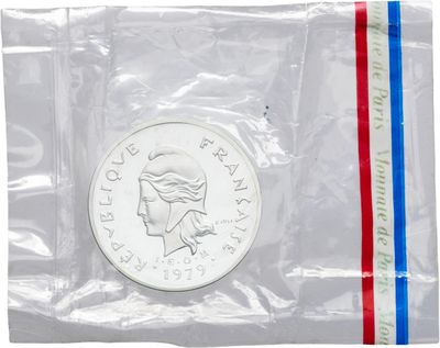 La pièce se trouve dans un sachet en plastique transparent orné d'une bande rouge, blanche et bleue.