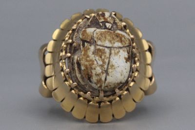 une image représentant une bague en or ornée d'une pierre en forme de scarabée au centre
