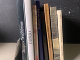 Plusieurs livres sont alignés sur une étagère devant un mur noir