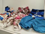 several pairs of swim shorts are lined up on a shelf