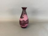 a purple vase sitting on a table with a white wall in the background