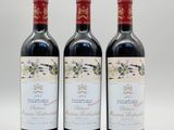 trois bouteilles de vin rouge posées l'une à côté de l'autre sur une surface blanche