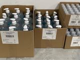 plusieurs cartons d'eau en bouteille posés à même le sol