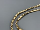 a close up of a gold chain on a gray surface