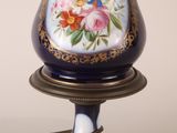 a lamp that is sitting on a stand with flowers on it