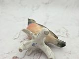 a small figurine of a bird with a pencil sticking out of it ' s mouth