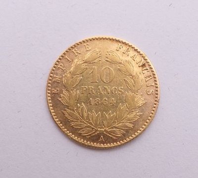 gros plan d'une pièce d'or sur une surface blanche