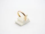 a close up of a gold ring sitting on top of a white marble block