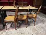 une table avec quatre chaises et une table sur laquelle se trouve un vase