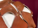 a close up of a mannequin wearing a brown leather vest