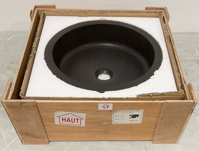 une caisse posée par terre, contenant un lavabo noir