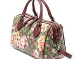 a women ' s handbag with a floral pattern and brown leather handles