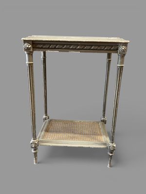 une table blanche surmontée d'une étagère en osier
