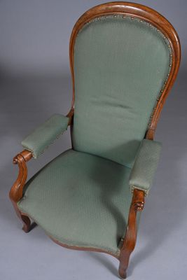 une chaise à l'ancienne avec une assise rembourrée verte et un piètement en bois