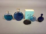 trois flacons de parfum bleu posés les uns à côté des autres sur une table