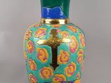 a vase with a cross on it sitting on a table