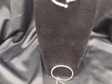un collier, un bracelet et une boucle d'oreille exposés sur un tissu noir