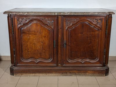 an old wooden cabinet with a marble top on a tiled floor