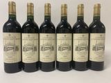 six bouteilles de vin sont alignées sur une surface blanche
