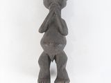figurine of a man with hands in his mouth