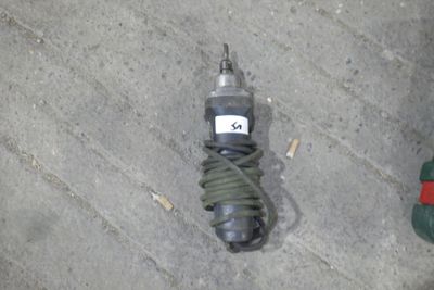 une photo d'une perceuse posée par terre à côté d'un cordon