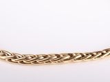 a close up of a gold necklace on a white surface