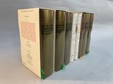 six books are lined up in a row on a white surface
