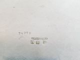an antique silver plate with writing on the side of it