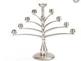 un chandelier en métal argenté à cinq bougies, posé sur un socle