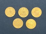 quatre pièces d'or posées sur une surface bleue