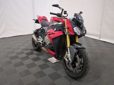 une photo d'une moto rouge et noire garée sur un sol à damier noir et blanc