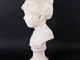 a white marble bust of a boy on a pedestal