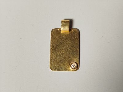 un gros plan d'un pendentif en or orné d'un diamant