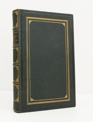 un livre noir aux bords dorés posé sur une table blanche