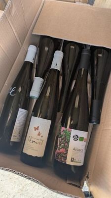 six bouteilles de vin dans un carton posé par terre